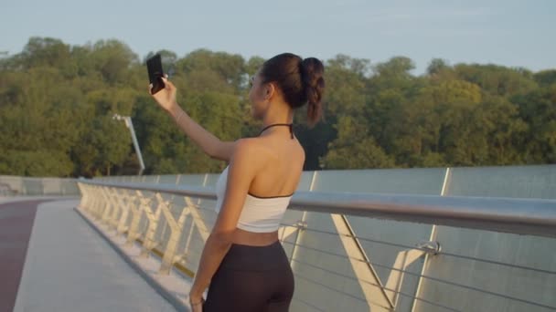 Donna in forma sportiva che prende selfie al telefono all'alba — Video Stock