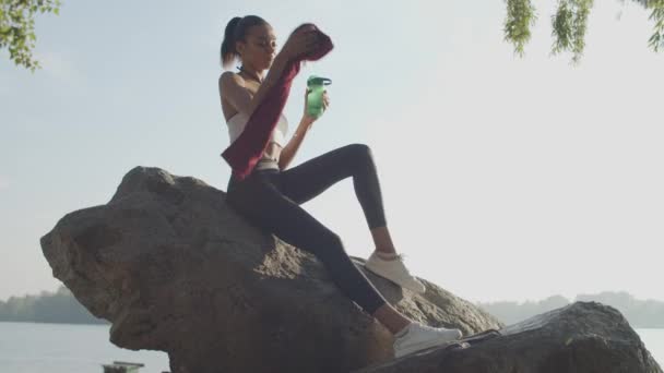 Kvindelig atlet hviler efter at have kørt motion – Stock-video