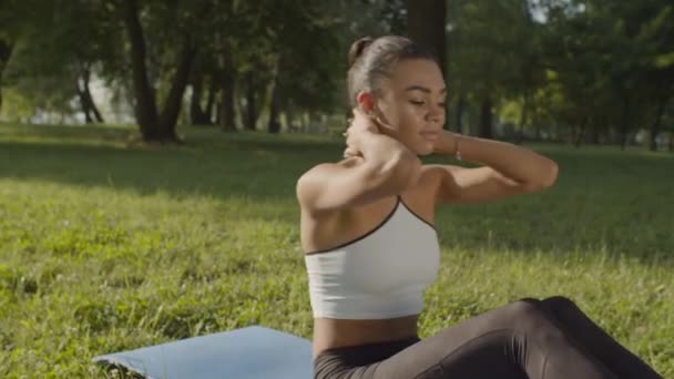 Mujer en forma deportiva activa haciendo abdominales crujidos en el parque — Vídeos de Stock