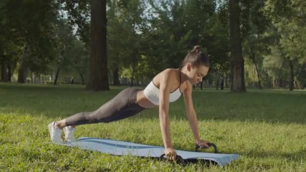 Aktive Frau trainiert mit Fitness-Liegestützstangen — Stockvideo