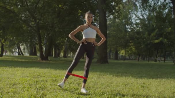 Mujer fitness haciendo ejercicio con banda de resistencia — Vídeo de stock
