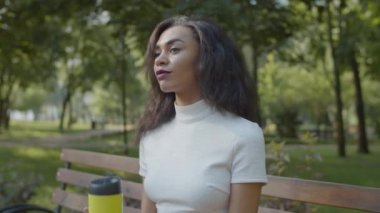 Güzel, siyah bir kadın, dışarıda kahve içiyor.