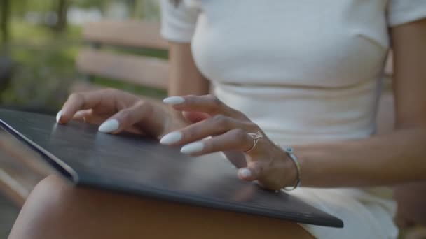 Mano femenina tocando los dedos en el portapapeles al aire libre — Vídeos de Stock