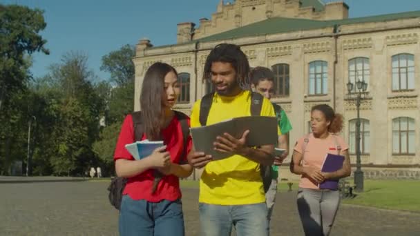 Разнообразные студенты, идущие на занятия на свежем воздухе — стоковое видео