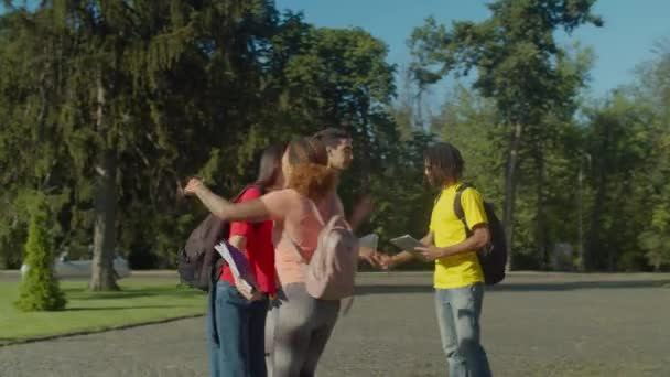 Casal multiétnico dizendo adeus a colegas estudantes — Vídeo de Stock