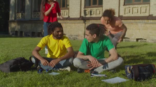 Nadšení vysokoškoláci setkání na školním trávníku — Stock video