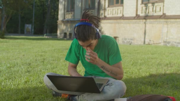 Estudiante árabe masculino con portátil e-learning al aire libre — Vídeo de stock