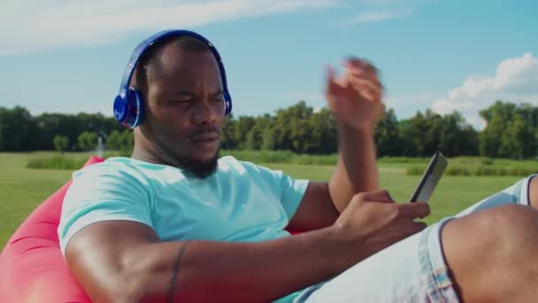 Homme détendu répondant à un appel téléphonique sur une chaise longue — Video