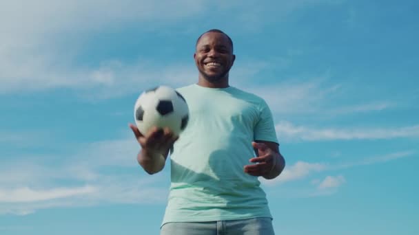 Jugador de fútbol alegre sosteniendo la pelota al aire libre — Vídeos de Stock