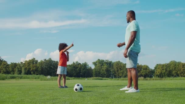 Pequeno árbitro de futebol mostrando cartão vermelho para o pai no parque — Vídeo de Stock