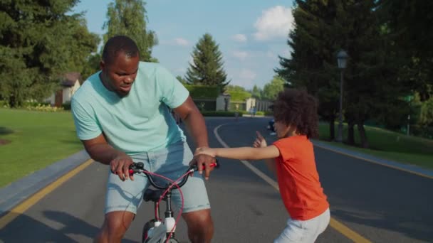 Kleine zoon verbiedt vader paardrijden kids fiets — Stockvideo