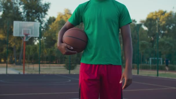 Mittelteil des Sportlers mit Basketball auf dem Außenplatz — Stockvideo