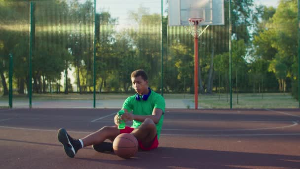 Jogador de basquete beber água na quadra ao ar livre — Vídeo de Stock