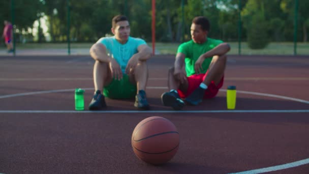 Баскетболисты наслаждаются отдыхом после матча — стоковое видео