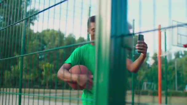 Joueur de Streetball avec téléphone en direct sur le court — Video