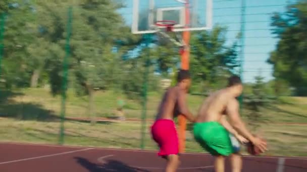 Hemdlose Sportler spielen Basketball auf dem Platz — Stockvideo