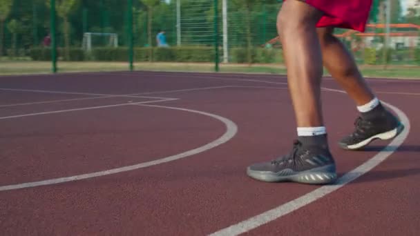 Athlète sur terrain de basket extérieur dribble ball — Video