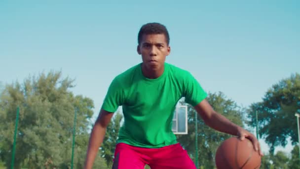アスレチック黒人男性が屋外でバスケットボールをする — ストック動画