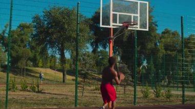 Basketbolcu, takım arkadaşı yardımından sonra sayı yapıyor.
