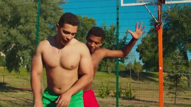 Dos amigos sin camisa jugando baloncesto en la cancha — Vídeos de Stock