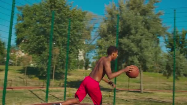 Streetball player making slam dunk over defender — Stock Video