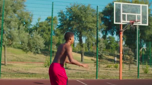 Shirtless jogador de basquete slam dunking na corte — Vídeo de Stock