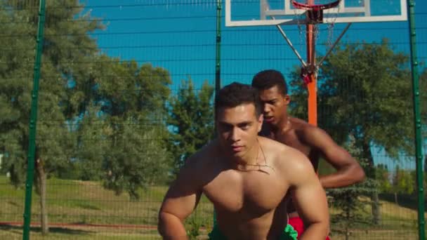 Joueurs de streetball athlétiques jouant sur un terrain urbain — Video