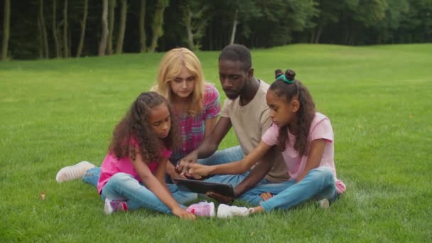 Různorodá rodina s dcerami pomocí tabletu PC venkovní — Stock video