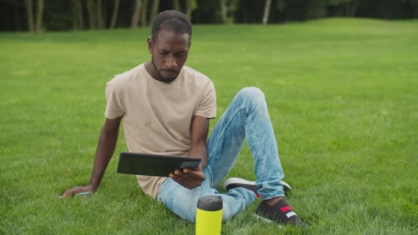 Africain homme réseautage sur tablette PC en plein air — Video