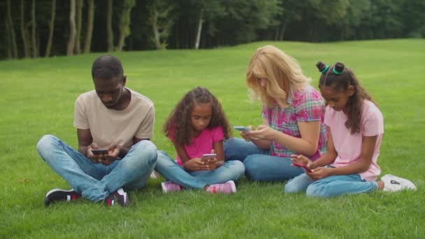 Telefone viciado família ignorando uns aos outros ao ar livre — Vídeo de Stock