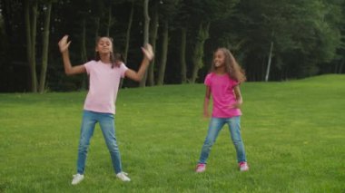 İki Afrikalı kız kardeş parkta hip hop yapıyor.