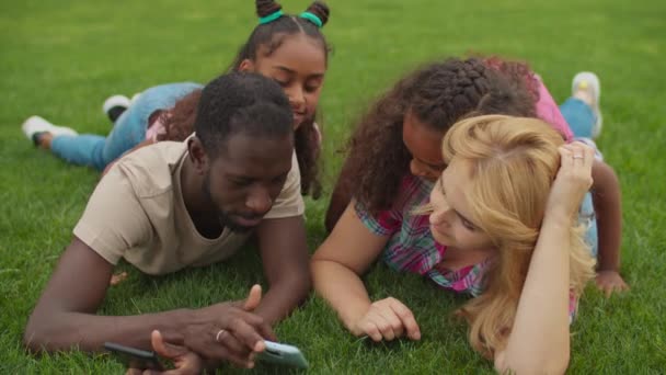 Diversos padres con niñas que trabajan en el teléfono inteligente — Vídeo de stock