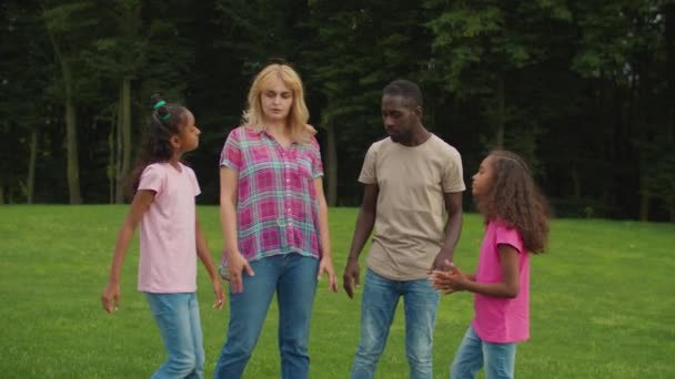 Família multiétnica alegre com meninas empilhando mãos — Vídeo de Stock