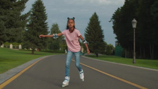 Härligt glad afrikansk flicka rollerblading i parken — Stockvideo