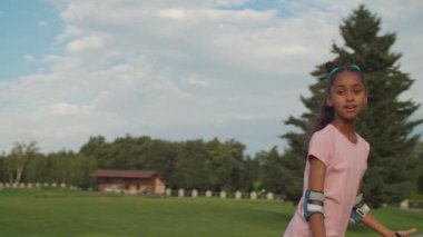 Parkta paten süren tatlı melez kız.