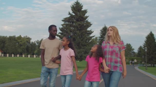 Família multiétnica de mãos dadas andando ao ar livre — Vídeo de Stock