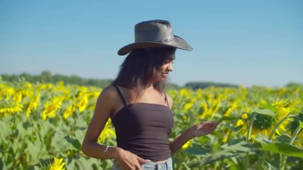 Bonde kvinna i cowboy hatt i solrosfält — Stockvideo
