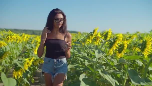 Precioso agricultor femenino eximining planta en el campo — Vídeos de Stock