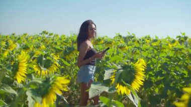 Mutlu kadın çiçek açan tarlalarda selfie çekiyor.