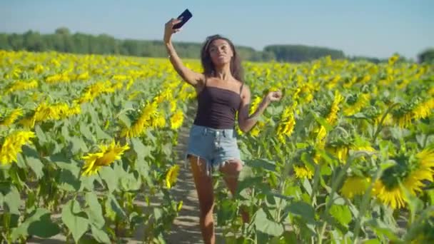 Ayçiçeği tarlasında selfie çeken güzel bir kadın. — Stok video