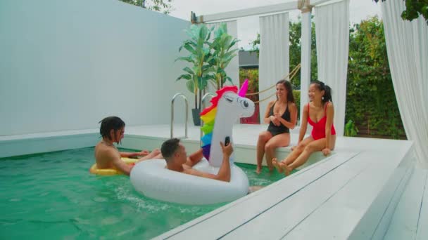 Glada män på uppblåsbara ringar flyter i poolen — Stockvideo