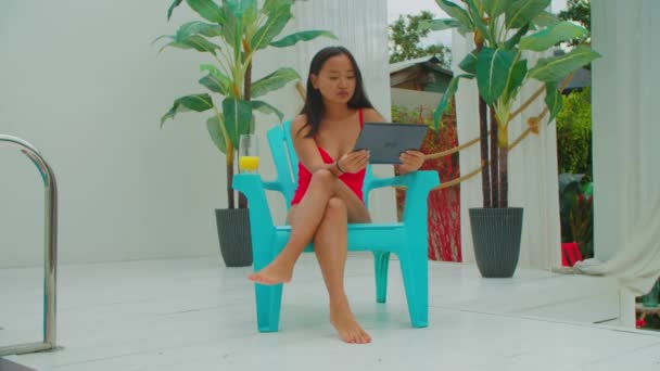 Asiatique fille réseau avec tablette pc au bord de la piscine — Video