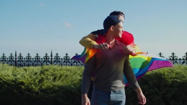Loving gay wrapping zijn man liefhebber met trots vlag — Stockvideo