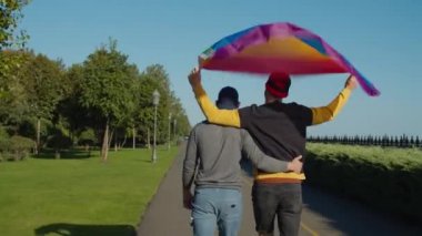 Dışarıda dolaşan lgbt bayrağıyla homoseksüel çift