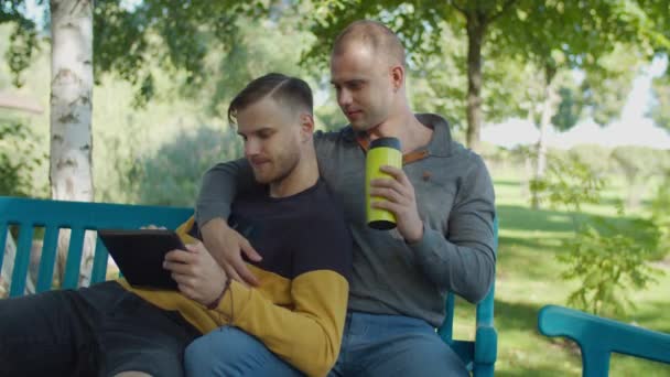 Älskade samkönade manliga par vilar i parken — Stockvideo