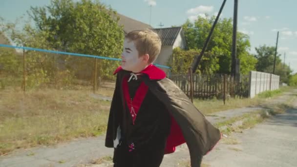 Kid in halloween vampire costume running on street — Stock Video