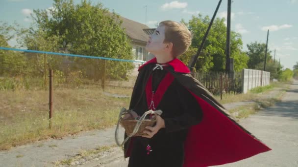 Jongen in Halloween kostuum op zoek naar traktatie buiten — Stockvideo