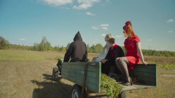 Grim reaper on mini tractor driving away lost souls — Stock Video