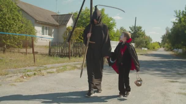 Hermanos en disfraces de Halloween celebrando la fiesta — Vídeos de Stock