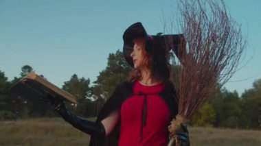 Beyaz cadı günbatımında kitapla büyü okuyor.